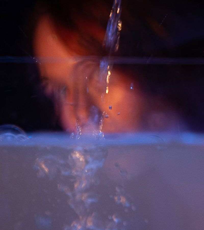 Woman in a light blue top performing a fluid cardio movement in a bright studio.